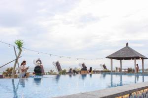 库塔库塔海滨酒店的一群人坐在游泳池周围