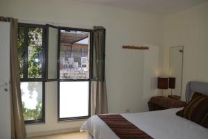 萨法德Artists Colony Inn Zefat的一间卧室设有一张床和一个大窗户