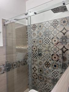 托尔托利Longevity Hotel的一间带淋浴的浴室和瓷砖墙