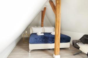 施韦青根Schlossberg Residences - XXL-Design-Apartment mit Schlossblick für bis zu 10 Personen的一间卧室配有一张带蓝色床单的天蓬床