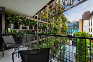 第比利斯第比利斯伊奥塔酒店的大楼内的阳台配有椅子和植物