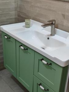 尼夫佐哈זוהר במדבר ים המלח的浴室配有绿色水槽和白色的台面