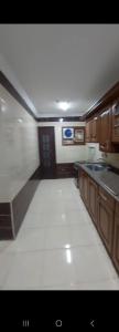 塞得港الفيصل的厨房铺有白色地板,配有木质橱柜。