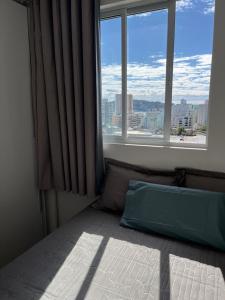 伊塔佩马Apartamento à 400m do mar的一间卧室设有一张床和一个大窗户