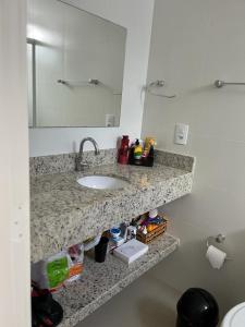 伊塔佩马Apartamento à 400m do mar的浴室的柜台设有水槽和镜子