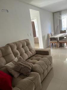 伊塔佩马Apartamento à 400m do mar的客厅配有一张棕色沙发,配有一张桌子