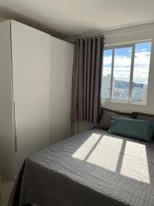 伊塔佩马Apartamento à 400m do mar的一间卧室设有一张大床和窗户