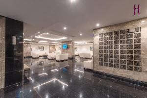 麦加Manazel Al Zaireen Hotel的大堂设有等候室,配有白色椅子和墙壁