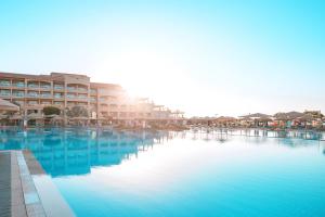 赫尔格达Pickalbatros White Beach Resort - Hurghada的建筑前方的一大片蓝色海水