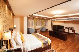 甘托克Denzong Regency- Luxury Mountain Retreat Spa & Casino的一间卧室配有一张大床和电视