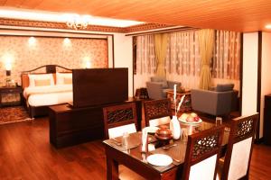 甘托克Denzong Regency- Luxury Mountain Retreat Spa & Casino的酒店客房设有餐桌和床。