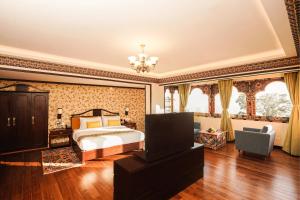 甘托克Denzong Regency- Luxury Mountain Retreat Spa & Casino的一间带一张床和吊灯的大卧室