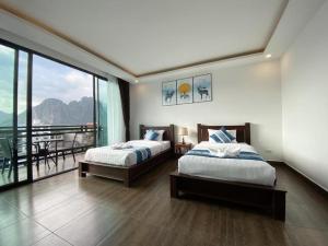 万荣VANG VIENG TOPVIEW HOTEL的一间带两张床的卧室和一个阳台