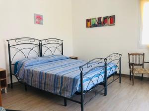 马蒂诺Casa nel Salento da Nico的一间卧室配有一张带蓝色被子和椅子的床