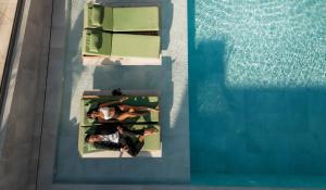 赫索尼索斯Paralos Venus Suites Adults Only的游泳池内两人的顶部景色