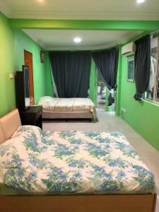 乔治市Supreme Homestay的一间卧室设有两张床,拥有绿色的墙壁