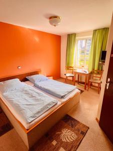 SchalksmühleHotel zur Post的一间卧室配有一张橙色墙壁的床