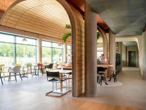 塞尔奈greet hotel Cernay Mulhouse的大型客房设有桌椅和窗户。