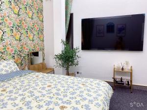 河内FlowerGod Apartments - BlackPink HomeStay的一间卧室配有一张床和一台平面电视