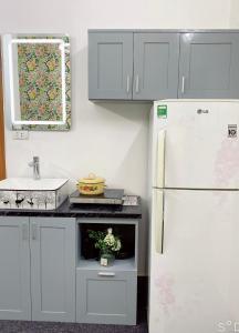 河内FlowerGod Apartments - BlackPink HomeStay的厨房配有白色冰箱和水槽