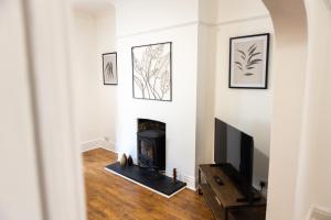 普里茅斯Fred's Place的客厅设有壁炉和电视。