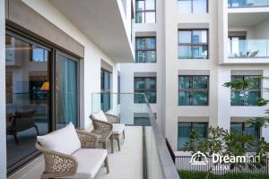 富查伊拉Dream Inn - Address Beach Residence Fujairah - Premium Apartments的阳台,位于带桌椅的建筑内