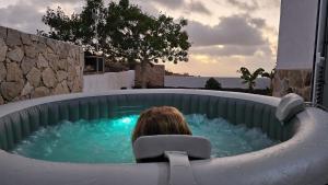 廷达亚Vivienda sostenible, vistas espectaculares的坐在后院热水浴缸中的女人