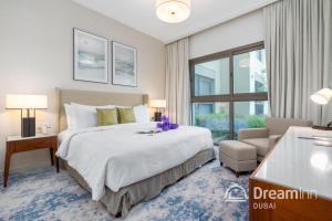 富查伊拉Dream Inn - Address Beach Residence Fujairah - Premium Apartments的卧室配有床、椅子和窗户。