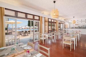 丰沙尔Dorisol Mimosa Studio Hotel的一间带桌椅的餐厅和一个游泳池