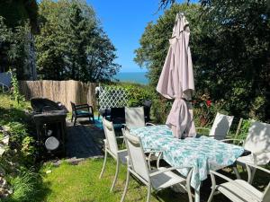 滨海图维列Spacieux appartement jardin, BBQ, vue sur mer, Trouville的桌椅、雨伞和烧烤架