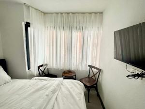 伊斯坦布尔Noya Suites的一间卧室配有一张床、两把椅子和一个窗户