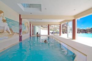 普拉基亚斯卡吕普索克莱顿田园假日及温泉酒店的在房子里游泳池游泳的人