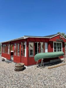 欧登塞Fjordhytten. Rebuild train wagon from 1937.的前面有绿色的红色房子