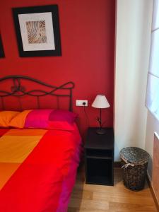 圣伊西德罗Acogedor apartamento Estacion de esqui San Isidro的红色卧室配有一张带彩色毯子的床