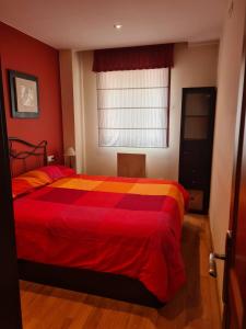 圣伊西德罗Acogedor apartamento Estacion de esqui San Isidro的一间卧室配有一张带红色和黄色毯子的床
