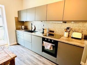 KronshagenBlaue Butze的厨房配有不锈钢用具,铺有木地板