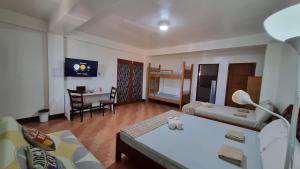 土格加劳PARB Tuguegarao的一间带两张床的房间和一间带桌子的客厅
