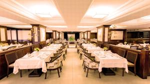 巴西利亚库比契克广场酒店的餐厅配有带白色桌布的桌子