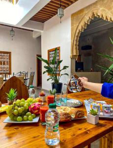 拉巴特Riad El Pacha的一张木桌,上面放着食物和水瓶