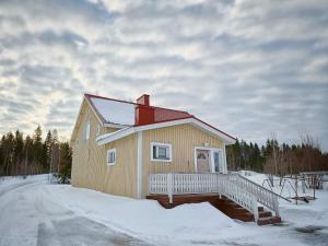 YlitornioMäki-mummola的雪地中带甲板的小房子