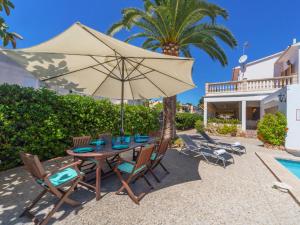 坎帕斯蒂利亚Villa antonio的庭院配有带遮阳伞和椅子的桌子