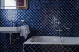 斯卡尔尼茨Scharnitz Chalet - gut eingerichtetes Haus的蓝色的浴室设有浴缸和水槽