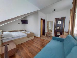 第聂伯罗Graff Hotel的一间卧室配有一张床和一张蓝色的沙发