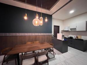 古晋Modern Stylish Apartment near Kuching Airport的一间带木桌和椅子的用餐室