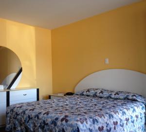 蒙特利尔圣雅克汽车旅馆的一间卧室设有一张床和黄色的墙壁