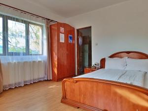 瓦莱德拉加努鲁伊Pensiunea Agroturistica Ica的一间卧室设有一张木床和一个大窗户。