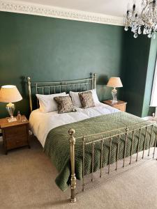诺里奇The Lodge at Salhouse的一间卧室设有一张大床和绿色的墙壁