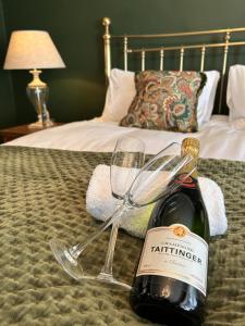 诺里奇The Lodge at Salhouse的床上有一瓶葡萄酒和一杯