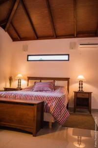 特玛斯德戴曼La Esquina - hermosa casa en Termas del Daymán的一间卧室配有一张床和两张台灯。