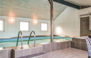 哈夫維格4 Bedroom Gorgeous Home In Hvide Sande的浴室内带两个水槽的游泳池